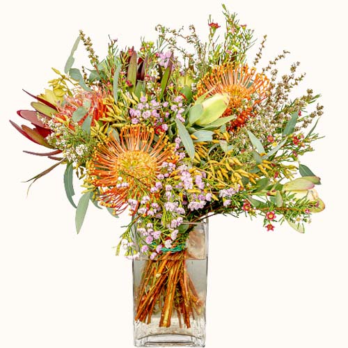 Multicoloured 'Autumn Sunshine' flowers in a small vase